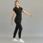 Modelo caminando con la filipina negra 905 y pantalón negro a juego, vista lateral.
